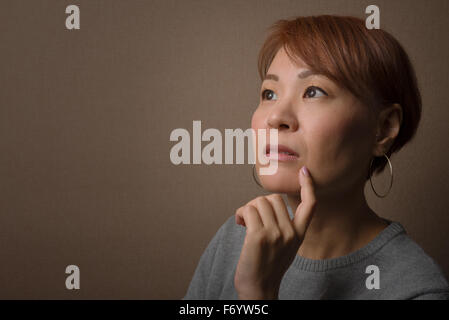 Ein Kopfschuss von einer nachdenklichen mittleren Alter Japanerin. Stockfoto