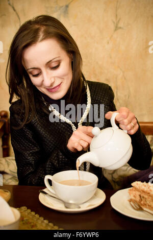 Frau einen Tee in der Cuptea gießen Stockfoto