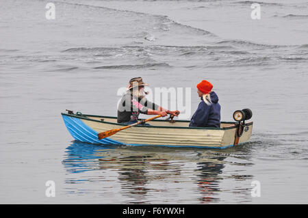 Mann und Frau in ihrem Boot auf dem Meer Rudern. Stockfoto