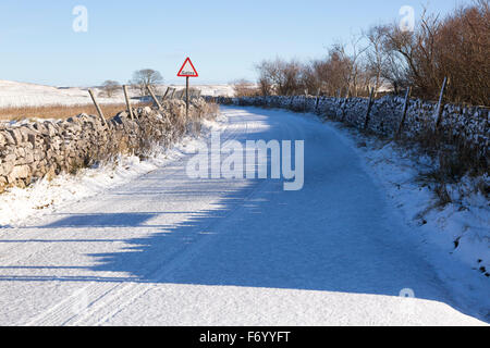 Schneebedeckte Straße auf Malham Moor im Winter mit einem Warnhinweis Stockfoto