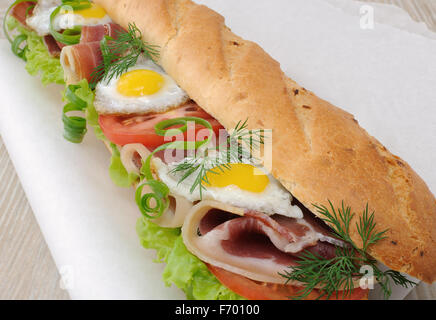 Big Sandwich mit Schinken, Tomaten und gebratenem Wachtelei Stockfoto