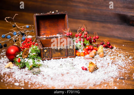 Weihnachten Winter Stillleben mit geöffneten leeren Brust, Apfel, Nüssen, Zapfen, Beeren, Tanne und Schnee, Nahaufnahme Stockfoto