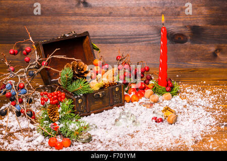 Weihnachten Winter Stillleben mit geöffneten voller Brust, Kerze, Apfel, Nüssen, Zapfen, Beeren, Tanne und Schnee, Nahaufnahme Stockfoto