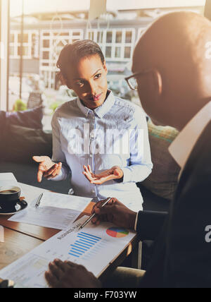 Schwarzen Geschäftsleute diskutieren die Diagramme und Grafiken zeigen die Ergebnisse der ihre erfolgreiche Teamarbeit Stockfoto