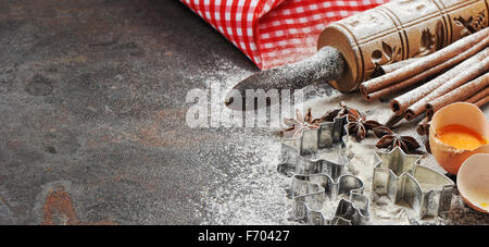 Weihnachten-Backzutaten und Maut für die Teigbereitung. Mehl, Eiern, Nudelholz und Ausstechformen Stockfoto