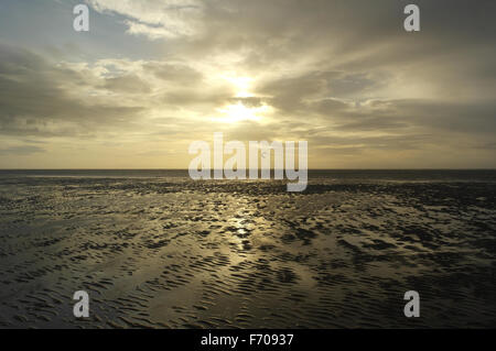 Blick über nassen Sandstrand Ausdehnung in Richtung Windsurfer unter grauen Wolken Sonnenuntergang, St Annes, Fylde Küste, Lancashire, UK Stockfoto