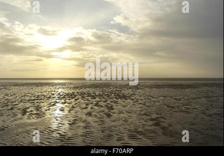 Blick über weite nassen Strand Sand in Richtung Windsurfer unter grauen Wolken blauer Himmel mit Untergang der Sonne, St. Annes Fylde Küste Stockfoto