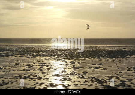 Graue Wolken, Blick auf den Sonnenuntergang über nasse Sonne-Schein Sand Strand in Richtung Windsurfer, St Annes, Fylde Küste, Lancashire, UK Stockfoto