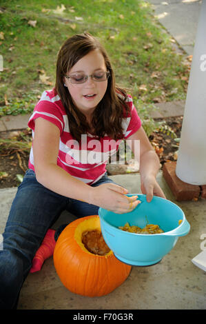 Pre-teen Mädchen einen Kürbis schnitzen Stockfoto