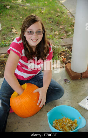 Pre-teen Mädchen einen Kürbis schnitzen Stockfoto