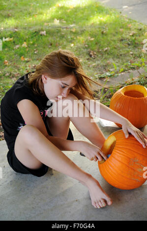 Pre-teen Mädchen einen Kürbis schnitzen Stockfoto