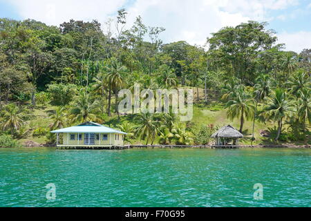 Direkt am Meer Hotel in Mittelamerika mit Kokosnuss-Palmen und ein Haus mit Hütte über Wasser, karibische Küste von Panama, Bocas Stockfoto