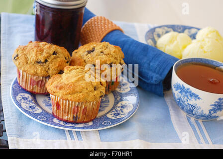 Vintage Teller mit Vollkorn (Weizen/Hafer/Mandel)-Blaubeer-Muffins mit Blaubeeren Marmelade, frische Butter und Tasse heißen schwarzen Tee Stockfoto