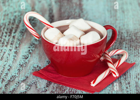 Heiße Schokolade mit Marshmallows und Zuckerstangen in eine rote Tasse Stockfoto