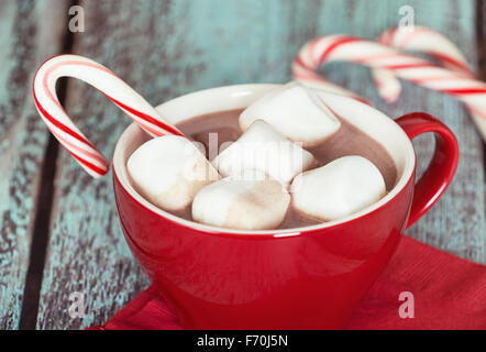 Heiße Schokolade mit Marshmallows und Zuckerstangen in eine rote Tasse Stockfoto