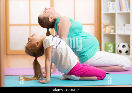 Schöne schwangere Frau mit älteren Kind Tochter Gym Fitness Übung Stockfoto