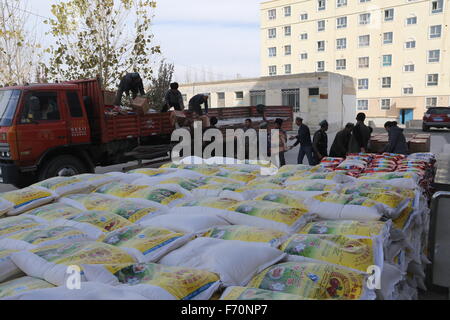 Pishan, Chinas Xinjiang Uygur Autonome Region. 21. November 2015. Menschen bekommen Reis und Mehl in Pixina Township Pishan Grafschaft, Nordwesten Chinas Xinjiang Uygur Autonome Region, 21. November 2015. Pixina Township war die am stärksten betroffenen Gebiet durch ein Erdbeben im Juli. Der 6,5-Beben erschütterte Pishan Grafschaft, weitgehend von den Leuten von Uygur Ethnie, am 3. Juli bewohnt und drei Tote und 263 verletzte. © Xu Xiaolong/Xinhua/Alamy Live-Nachrichten Stockfoto