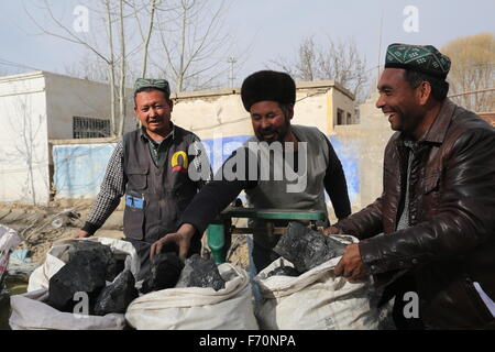 Pishan, Chinas Xinjiang Uygur Autonome Region. 21. November 2015. Dorfbewohner erhalten Kohlen in Pixina Township Pishan Grafschaft, Nordwesten Chinas Xinjiang Uygur Autonome Region, 21. November 2015. Pixina Township war die am stärksten betroffenen Gebiet durch ein Erdbeben im Juli. Der 6,5-Beben erschütterte Pishan Grafschaft, weitgehend von den Leuten von Uygur Ethnie, am 3. Juli bewohnt und drei Tote und 263 verletzte. © Xu Xiaolong/Xinhua/Alamy Live-Nachrichten Stockfoto