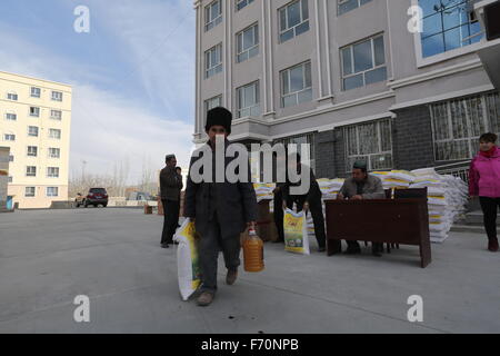 Pishan, Chinas Xinjiang Uygur Autonome Region. 21. November 2015. Menschen bekommen Reis und Mehl in Pixina Township Pishan Grafschaft, Nordwesten Chinas Xinjiang Uygur Autonome Region, 21. November 2015. Pixina Township war die am stärksten betroffenen Gebiet durch ein Erdbeben im Juli. Der 6,5-Beben erschütterte Pishan Grafschaft, weitgehend von den Leuten von Uygur Ethnie, am 3. Juli bewohnt und drei Tote und 263 verletzte. © Xu Xiaolong/Xinhua/Alamy Live-Nachrichten Stockfoto