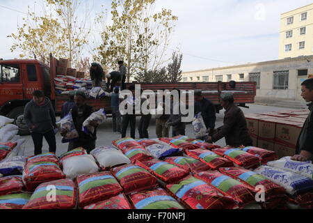 Pishan, Chinas Xinjiang Uygur Autonome Region. 21. November 2015. Menschen bekommen Reis und Mehl in Pixina Township Pishan Grafschaft, Nordwesten Chinas Xinjiang Uygur Autonome Region, 21. November 2015. Pixina Township war die am stärksten betroffenen Gebiet durch ein Erdbeben im Juli. Der 6,5-Beben erschütterte Pishan Grafschaft, weitgehend von den Leuten von Uygur Ethnie, am 3. Juli bewohnt und drei Tote und 263 verletzte. © Xu Xiaolong/Xinhua/Alamy Live-Nachrichten Stockfoto