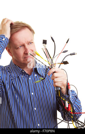 Älterer Mann mit vielen verschiedenen Kabeln in seine Hand schauen ratlos Stockfoto