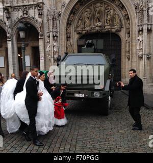 Die Hochzeit zu Fuß aus dem Rathaus im historischen Grande Place ist neben modernen gepanzerten Fahrzeug der belgischen Armee in Brüssel, 21. November 2015 fotografieren. Belgien hat Brüssel die höchste Terror-Warnstufe aufgrund der Bedrohung durch den Terrorismus gestellt. (CTK Foto/Jakub Dospiva) Stockfoto