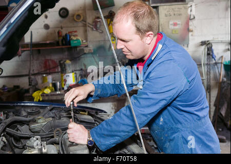 Kfz-Mechaniker arbeiten am Motor eines Autos, Stockfoto