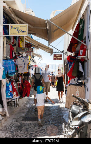 Santorini. Touristen zu Fuß durch die typischen engen gepflasterten Straße mit Geschäften auf beiden Seiten und Markisen Overhead, im alten Stadtzentrum von Fira entfernt. Stockfoto