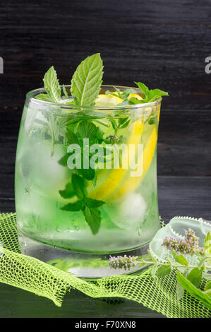 Hausgemachtes Mojito cocktail in einem gebogenen Glas auf dunklen Hintergrund Stockfoto