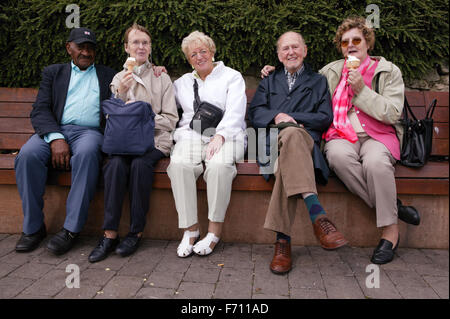 Gruppe älterer Menschen, die auf einer Bank sitzen, Stockfoto