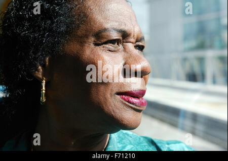 Porträt einer Frau aus einem Fenster lächelnd, Stockfoto