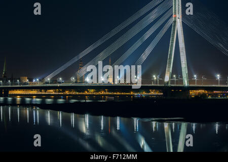 Kabel-gebliebene Brücke und Fluss Daugava in der Nacht, Riga, Lettland Stockfoto