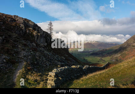 Eine Steinmauer liefen aus hohen Rigg in St. John's im Tal Tal mit Schnee bedeckt Blencathra in der Ferne Stockfoto