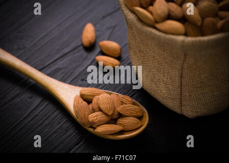 Mandel in Sack auf schwarzer Holztisch. Stockfoto