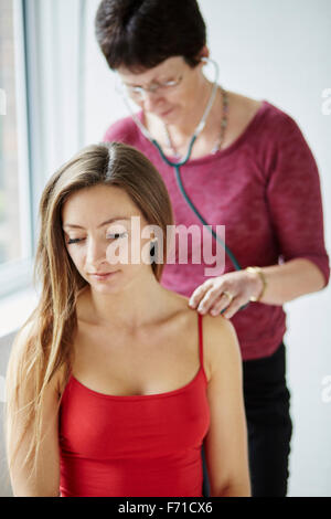 Arzt Patienten zurück und Brust anhören Stockfoto