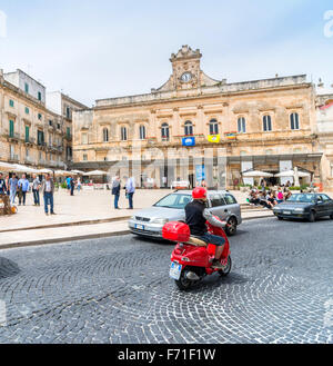 Touristen besuchen die Altstadt und die Statue des San Oronzo in Ostuni, Italien. Stockfoto