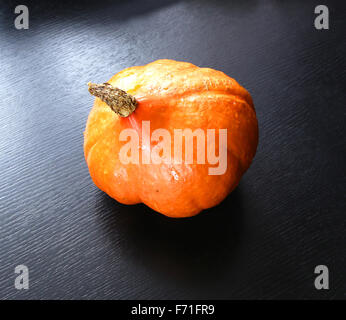 Orange Kürbis roh frisch auf schwarz glänzend Stockfoto
