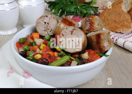 Scheiben von hausgemachten Wurstwaren mit Gemüse Stockfoto