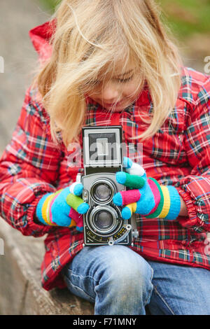 Nahaufnahme von Mädchen zu fotografieren und betrachten Vintage analog zweiäugigen Spiegelreflex-Kamera, Aufnahme Stockfoto