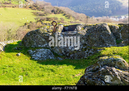 Altes Eisen Anbindehaltung Ring für Rinder in der Nähe ein gemeißelt Loch im Felsen für Wasser oder Futter auf dem walisischen Hügel gesetzt. Stockfoto