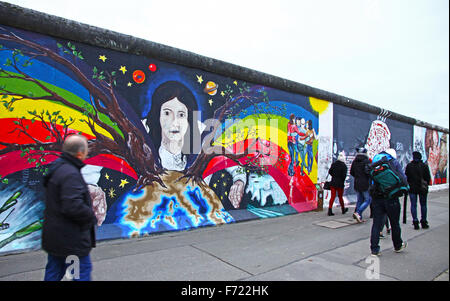 BERLIN - 10. November 2013: Passanten in der Nähe von East Side Gallery am 10. November 2013 in Berlin, Deutschland. Es ist ein 1,3 km langen Teil der original Berliner Mauer, die 1989 zusammengebrochen, und jetzt ist der größten Welt Amateur Art Gallery of graffiti Stockfoto