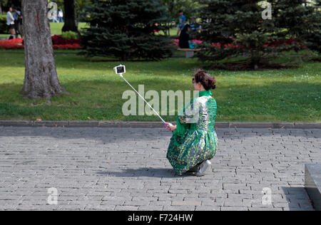Eine Frau, die eine Selfie mit einem Selfie-Stick im Kreml, Moskau, Russland. Stockfoto