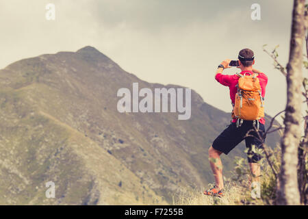 Wandern Mann, Backpacker, Bergsteiger oder Trailläufer in Bergen schöne inspirierende Landschaft betrachten. Unter Bild Stockfoto
