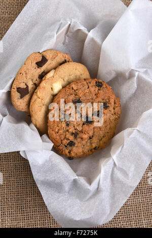 Erhöhte Ansicht für eine Schachtel mit sortierten Gourmet Cookies. Schokolade, Haferflocken Rosinen und White chocolate Chip Cookies Closeup in eine bo Stockfoto