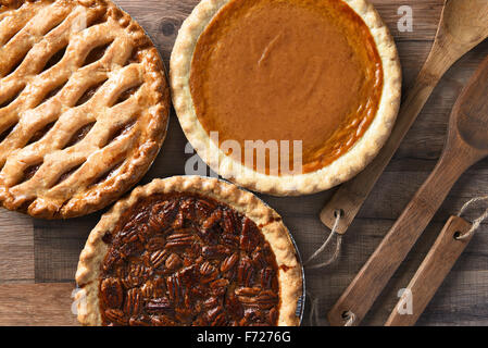 Draufsicht der drei Kuchen für ein Thanksgiving-Feiertag fest. Pekannuss, Apfel und Kürbis im Querformat auf Holztisch Stockfoto