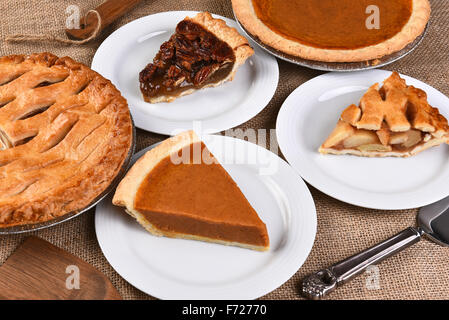 Erhöhte Ansicht von ganzen Torten und Platten mit Scheiben. Traditionelle Thanksgiving Desserts gehören, Pecan Pie, Apfelkuchen und Pumpki Stockfoto