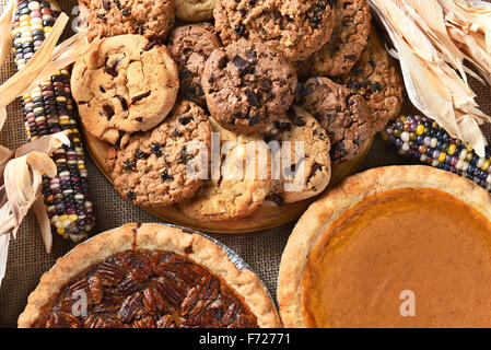 Nahaufnahme von Kuchen und Plätzchen für ein Erntedankfest fest Desserts. Pecan Pie, Pumpkin Pie, Chocolate Chip, Haferflocken Rosinen und in Stockfoto