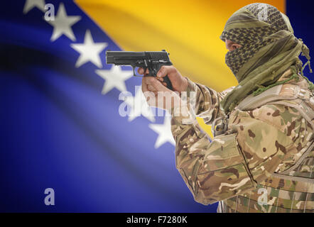 Männlich in muslimischen Keffiyeh mit Pistole in der Hand und Nationalflagge auf Hintergrund-Serie - Bosnien und Herzegowina Stockfoto