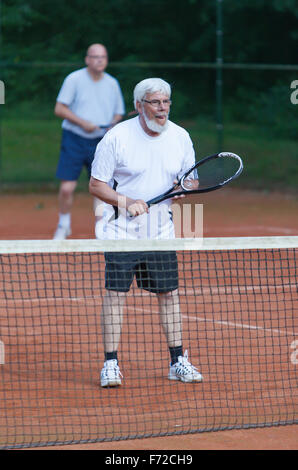 Senior woman Tennis spielen auf einem Kies-Gericht Stockfoto