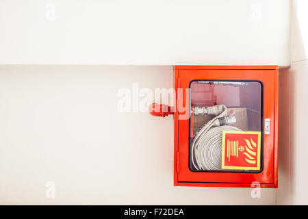 ein Feuerwehrschlauch hängt an der Wand in eine Treppe Stockfoto